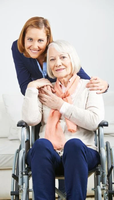 A carer walking with a resident through the residence gardens